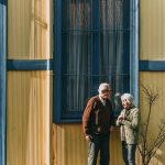 man and woman standing in front of building s window