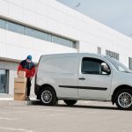 delivery man with boxes next to a white van